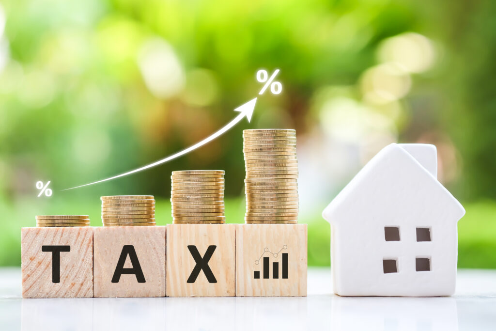 Landlords Face Higher Tax Bills From April 2027 House and stack of coin on the wood block with TAX text and white arrow show increase of interest rates. planning savings money of coins to buy a home concept for property ladder, mortgage.